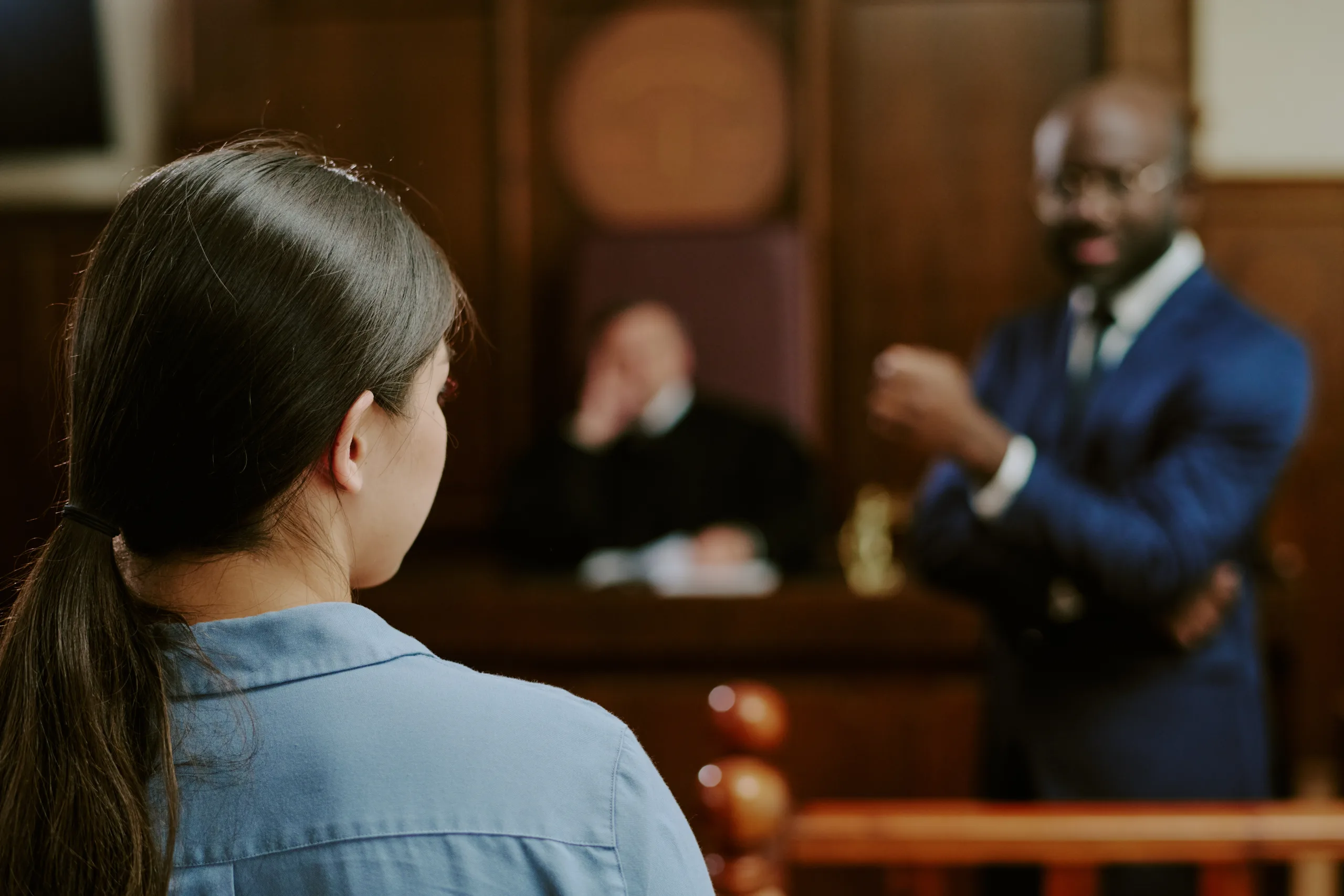 Young Caucasian Woman Testifying in Courtroom with Black Man Questioning